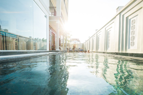 Una piscina al aire libre, sombrillas, tumbonas