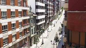 A multi-story building with a mix of brick and white facades, featuring balconies and a clear street view. - Hotel Rosal (Oviedo)