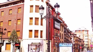 A street view with a pharmacy, a map sign, and classic European architecture. - Hotel Rosal (Oviedo)