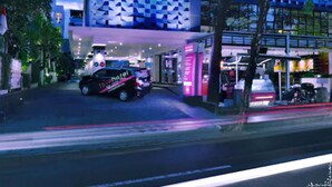 A modern hotel with a colorful checkered facade, a car in front, and a well-lit entrance. - favehotel Kuta Kartika Plaza (Kuta)