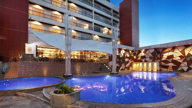 Un hotel con piscina, area relax all'aperto e design architettonico moderno.