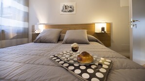 A neatly made bed with a polka dot tray, a pastry, and a cup of coffee. - Ciauru Design B&B (Messina)