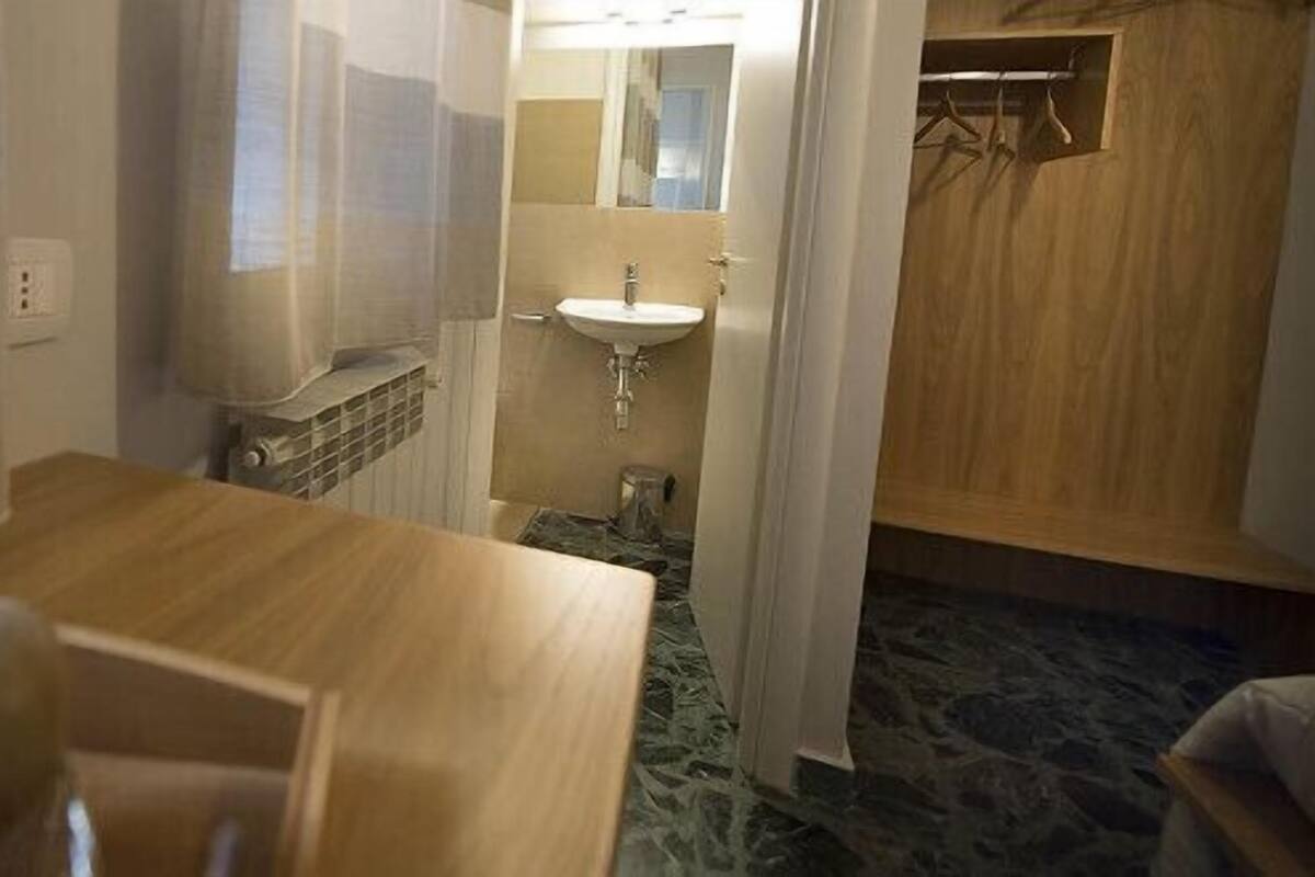 Une chambre d’hôtel avec une table en bois, un lavabo et un miroir.