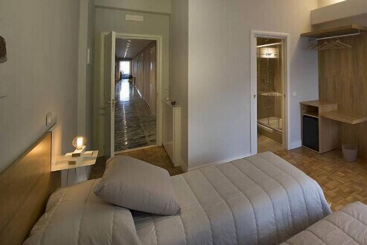 Une chambre à coucher comprenant un lit, un bureau, une chaise, un téléviseur et un dressing.