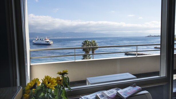 A room with a view of the ocean, a ship, and a palm tree. - Ciauru Design B&B (Messina)