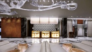 A modern lobby with a reception desk, seating area, and a chandelier. - Aston Pasteur (Bandung)