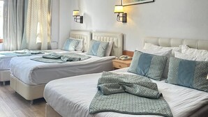 Ein Hotelzimmer mit zwei Betten, einem Gemälde, zwei Wandleuchten, einem Fenster mit Vorhängen und einer Deckenlampe.