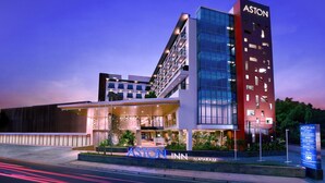 A modern hotel with a prominent "ASTON" sign, a glass facade, and a well-lit entrance. - Aston Inn Mataram (Mataram)