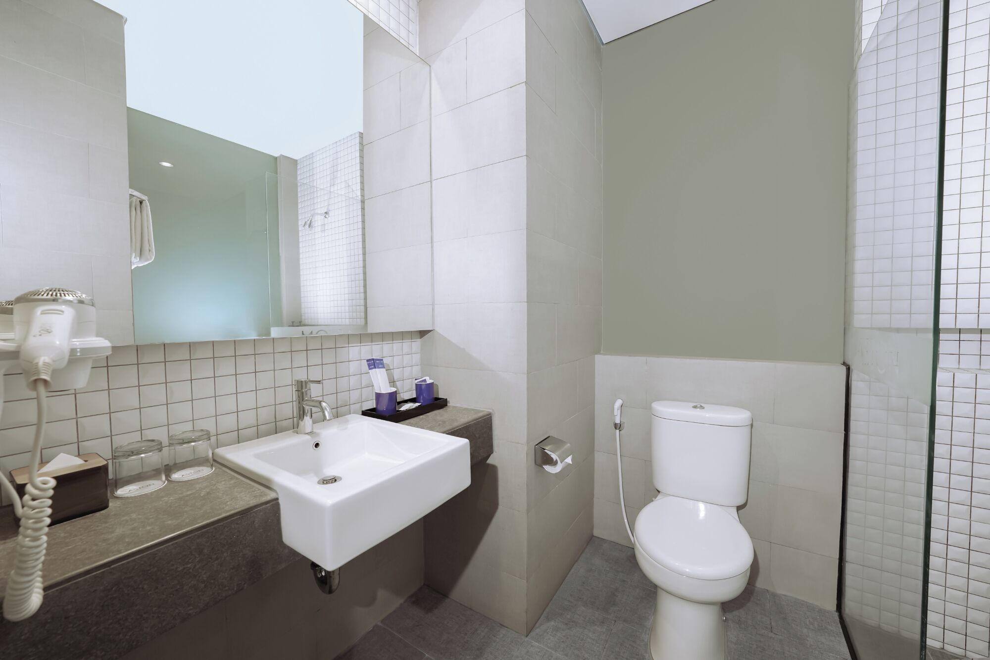Ein modernes Badezimmer mit Waschbecken, Spiegel und Toilette.
