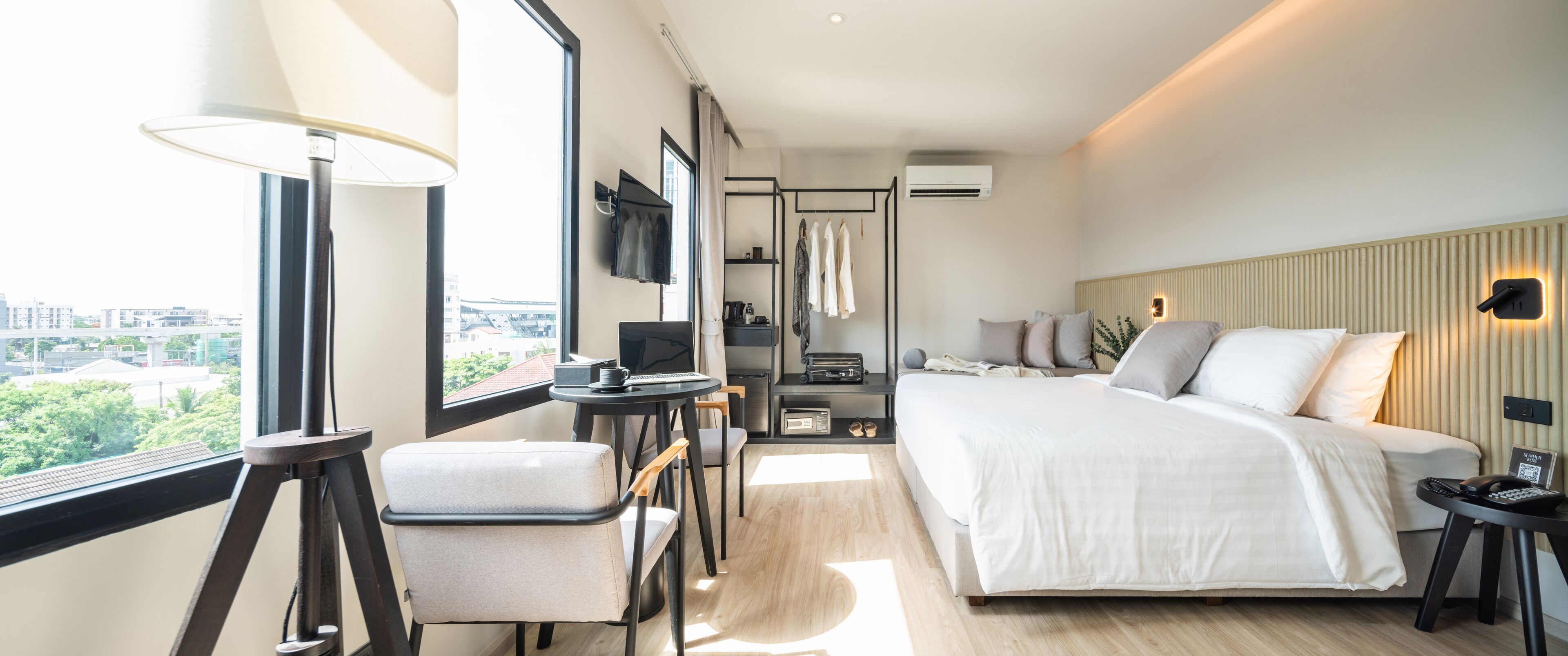 Une chambre d’hôtel moderne dotée d’un grand lit, d’un bureau, d’une chaise, d’une télévision et offrant une vue sur la ville.