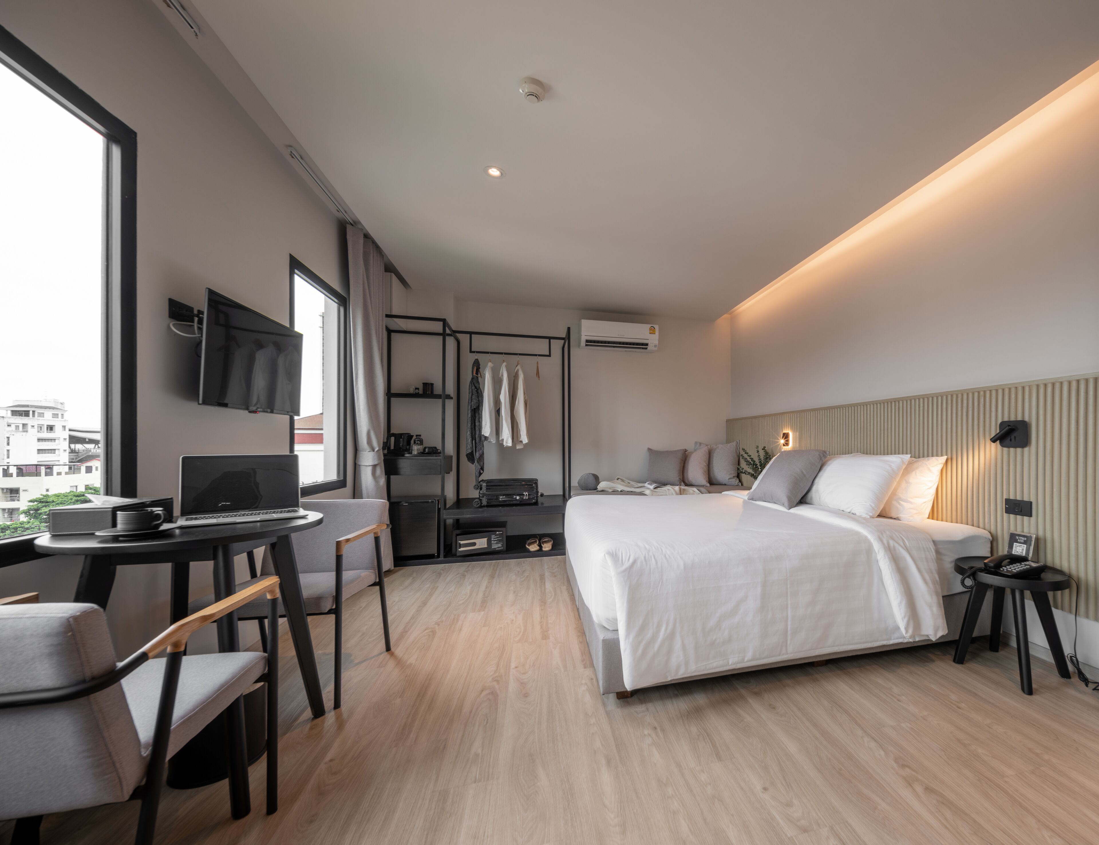 Una habitación de hotel moderna con cama, escritorio, silla y televisor.