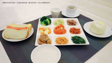 A meal tray with various food items including bread, vegetables, and a bowl of soup.