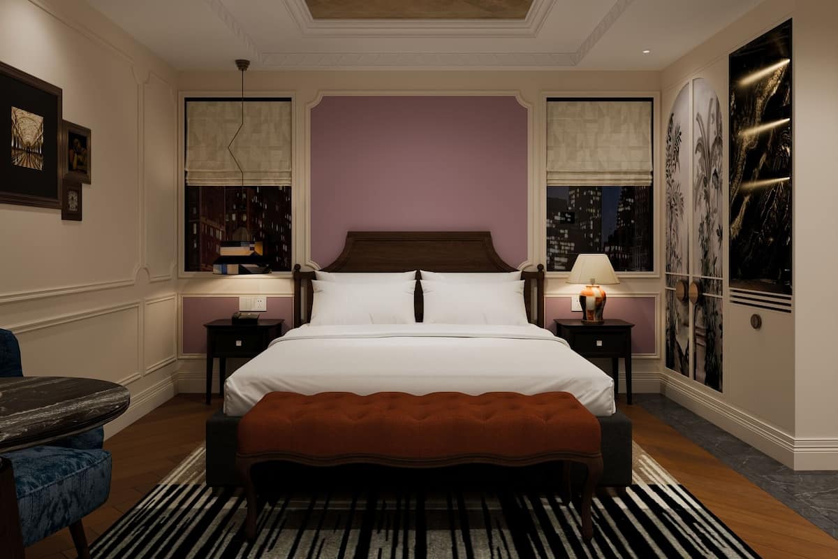 A hotel room with a large bed, two bedside tables, a chair, and a view of the cityscape.