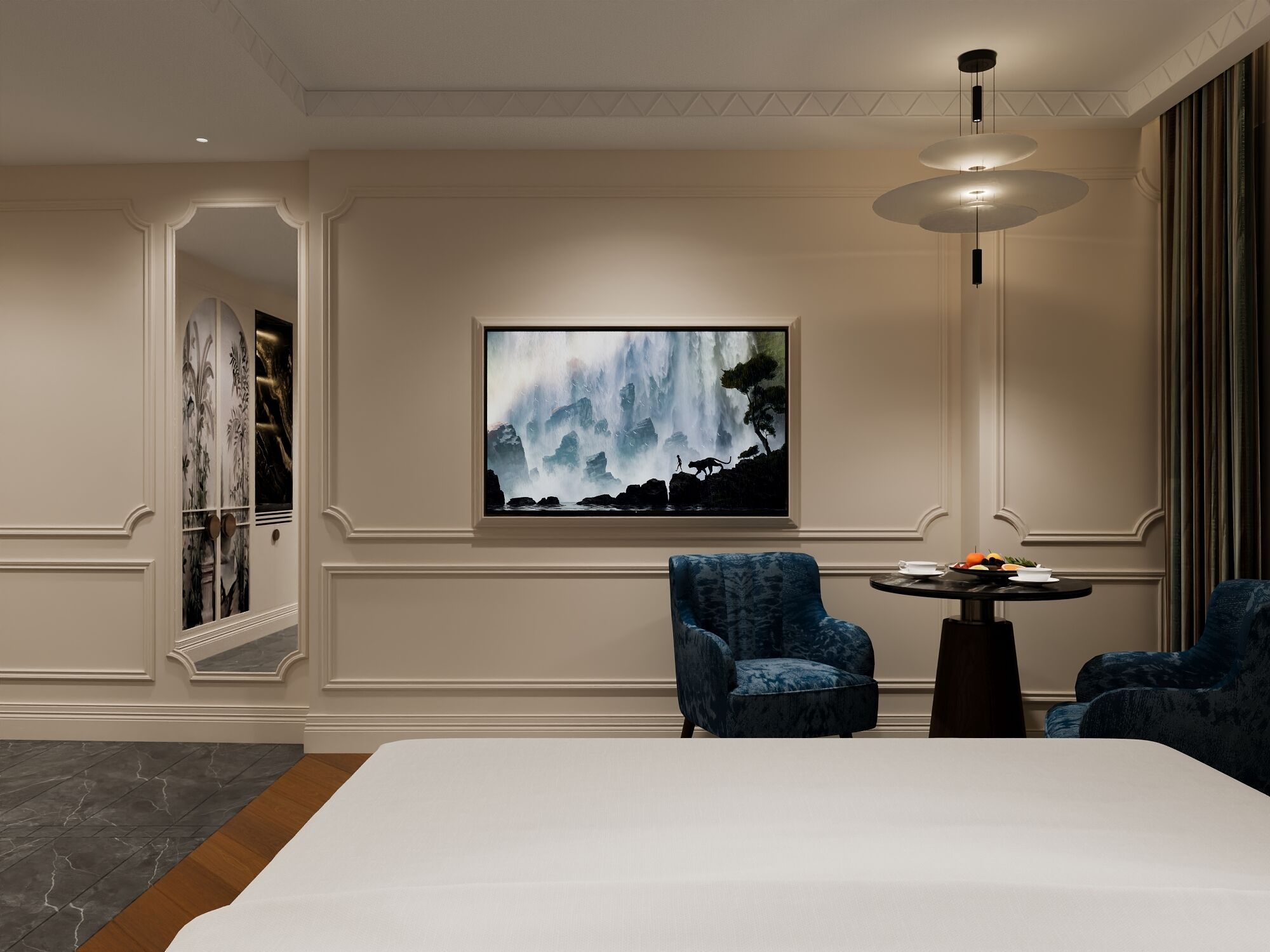 A hotel room with a large bed, two blue armchairs, a small table with a vase, and a large painting of a waterfall on the wall.