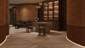 A modern interior with a central seating area, a wall-mounted shelf with bottles, and a tiled floor. - O'Gallery Signature Hotel & Spa (Hanoi)