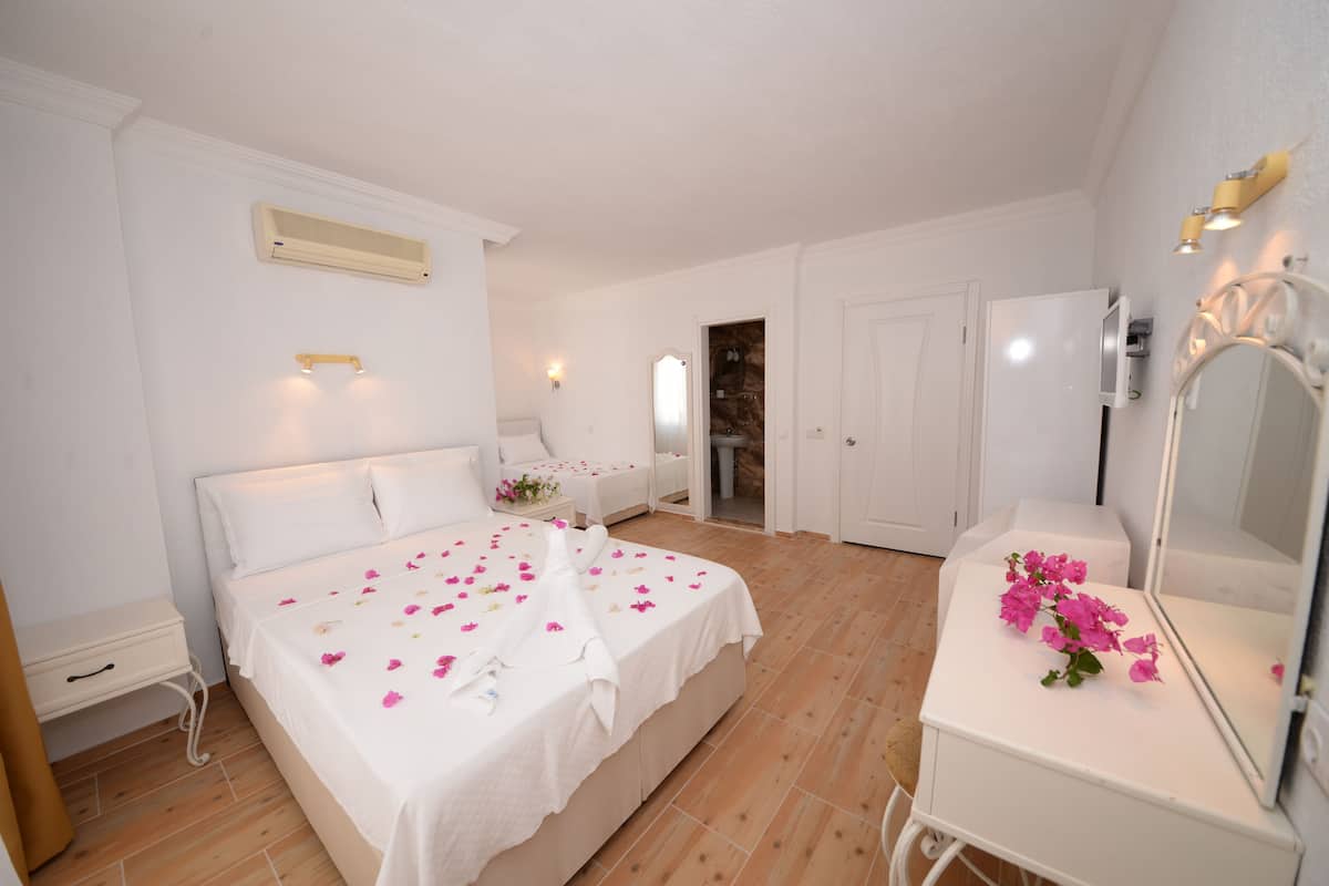 A bedroom with a bed, bedside tables, a mirror, and a door leading to a bathroom.