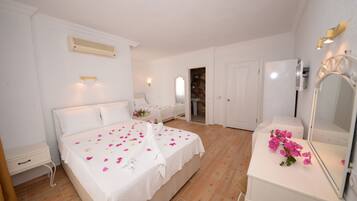 Ein Schlafzimmer mit einem Bett, Nachttischen, einem Spiegel und einer Tür zu einem Badezimmer.