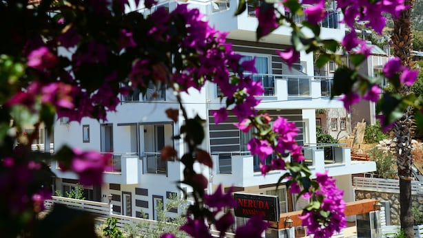 A modern building with balconies and a sign reading "NERUDA PANSINON". - Neruda Hotel (Kas)