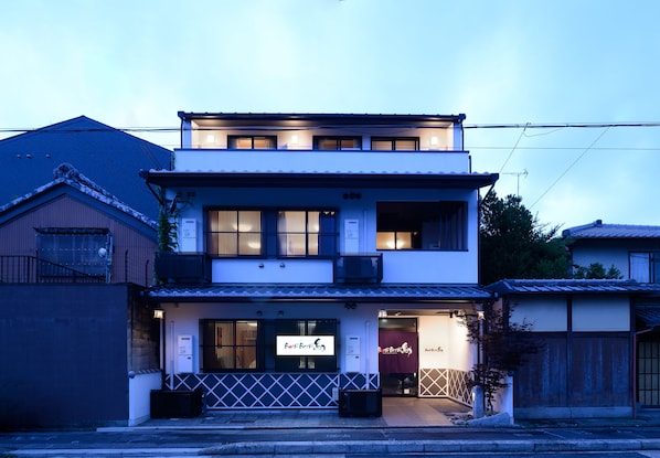 Un edificio de dos pisos con un letrero que dice 'Bar Bar Bar' en la entrada.