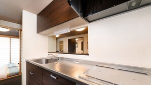Una cocina moderna con encimera de acero inoxidable, lavavajillas integrado y muebles de madera.
