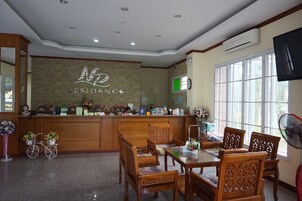 A reception area with a wooden desk, chairs, and a large window.