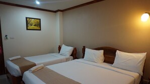A hotel room with two single beds, each with wooden headboards and white bedding. A framed picture hangs on the wall above the beds. - NP Residence (Nakhon Phanom)
