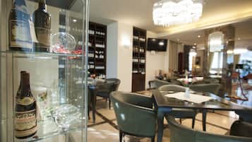 A restaurant interior with a wine display, dining tables, and chairs.