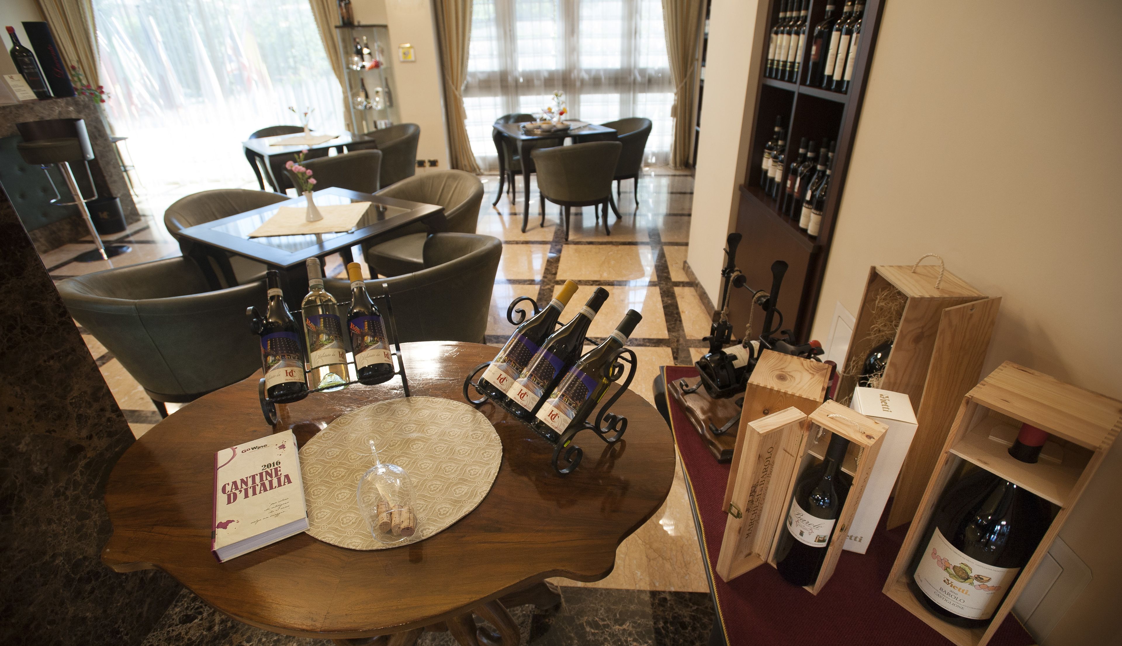 Un comedor con una mesa de madera, botellas de vino y un menú titulado "ANTINE D'ITALIA 2016".