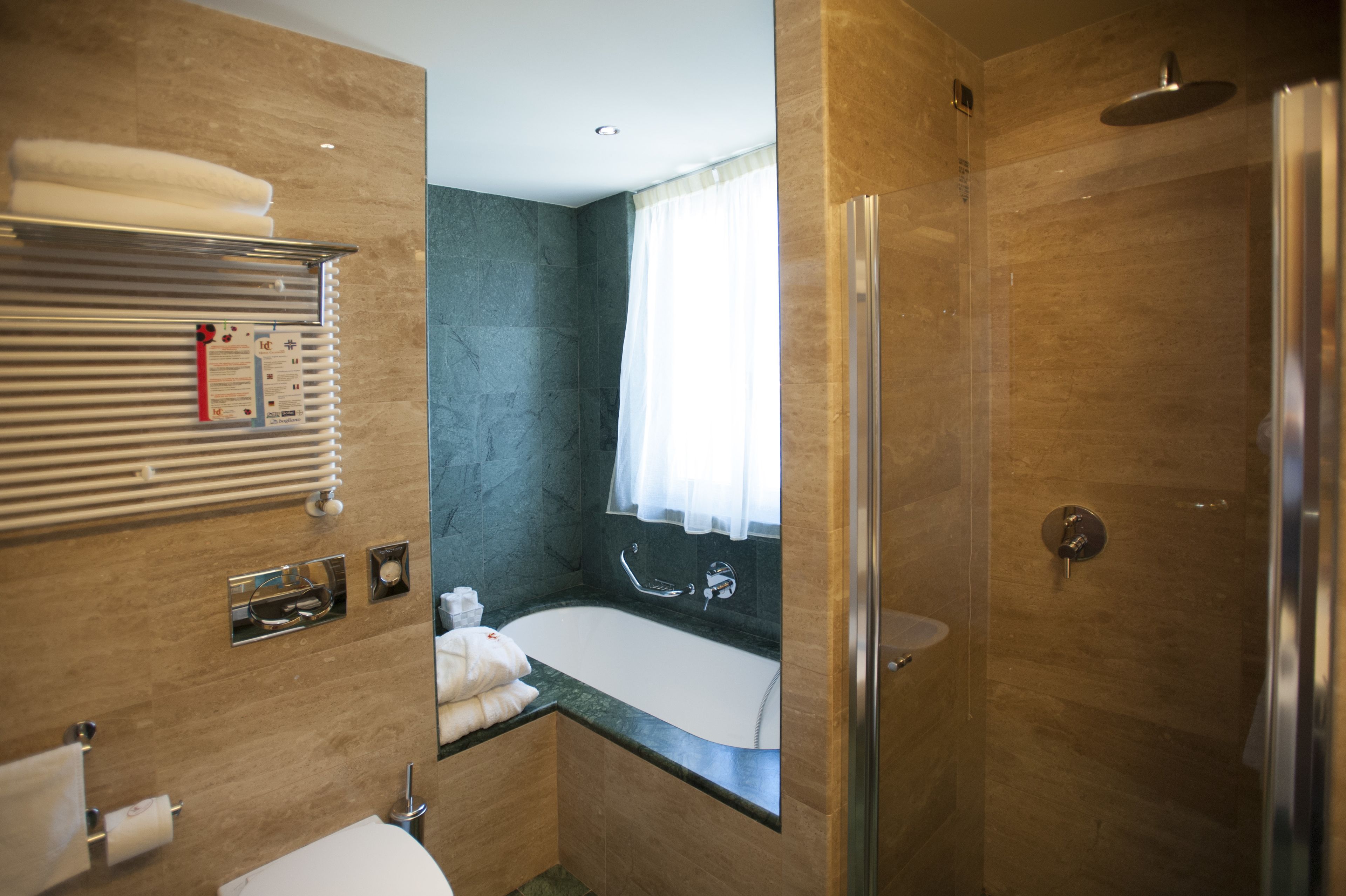A modern bathroom with a bathtub, shower, and toilet.