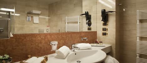 A modern bathroom with a large mirror, two sinks, a towel rack, and a heated towel rail.