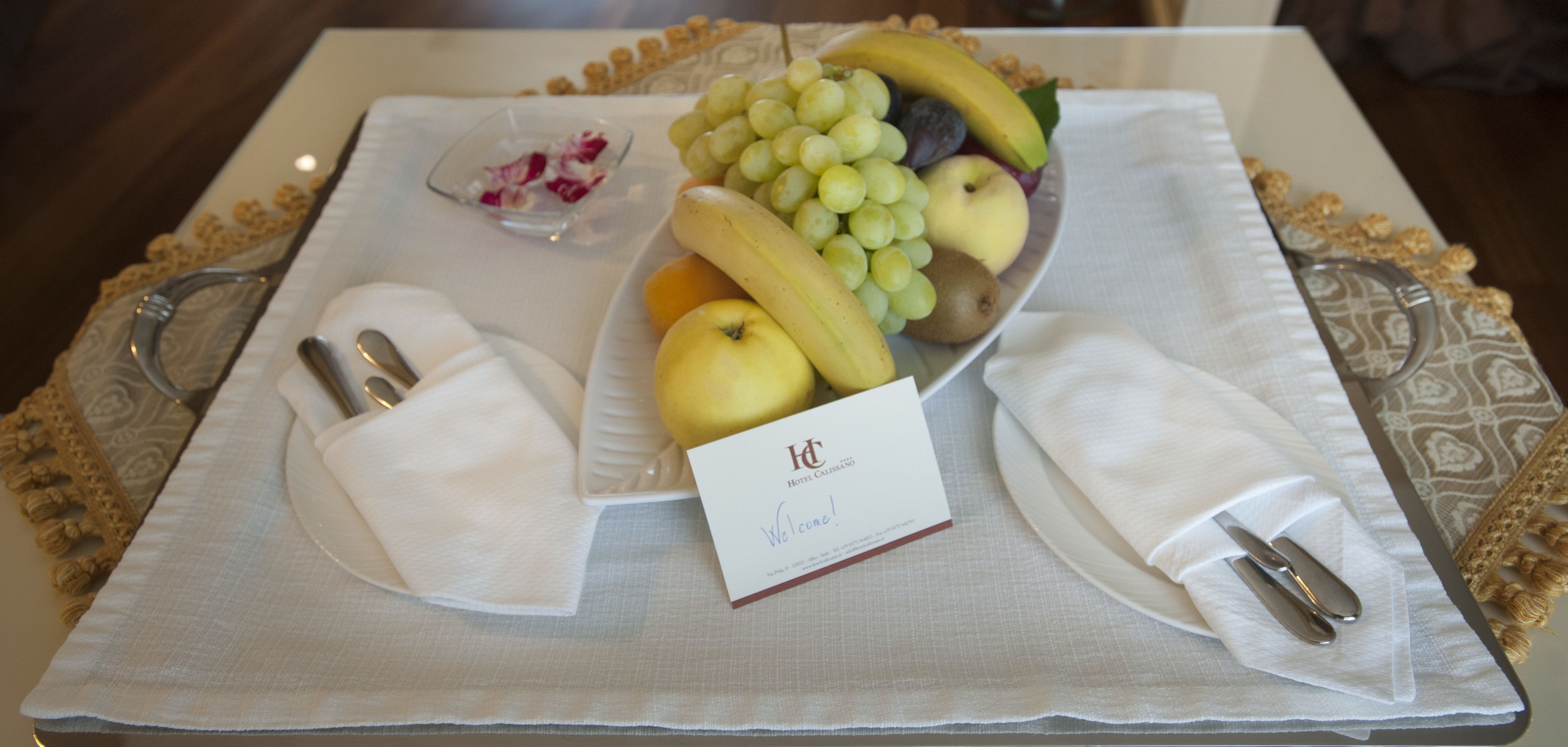 Una bandeja con frutas, una servilleta y una tarjeta de hotel sobre una mesa.