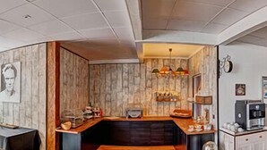 A modern kitchen with a wooden countertop, a built-in stove, and a hanging light fixture. - Shape Sport Hotel (Winsen (Luhe))