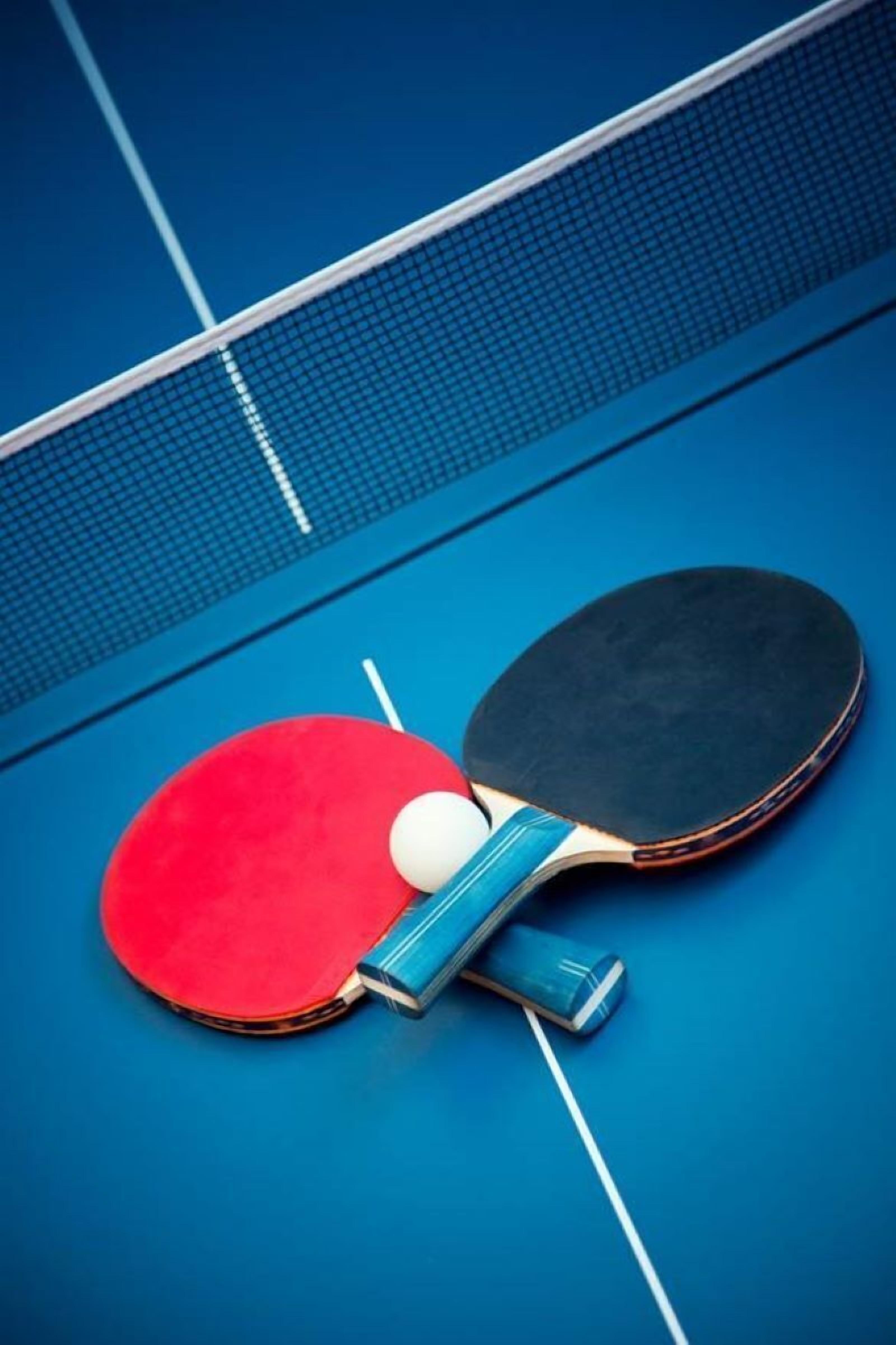 Two table tennis paddles on a blue table tennis table.