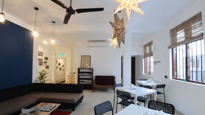 A modern living room with a sofa, a dining table, and a ceiling fan. - Star Anise Boutique Capsule (Colombo)