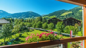 A view from a balcony overlooking a mountainous landscape with a road, green fields, and buildings. - Hotel Das Gastein - including Alpentherme entrance all year and including "Gasteiner Bergbahnen" during summer season (Bad Hofgastein)