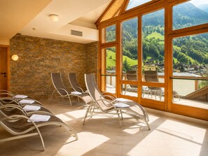 A sunlit room with stone walls and large windows overlooking a green landscape. - Hotel Das Gastein - including Alpentherme entrance all year and including "Gasteiner Bergbahnen" during summer season (Bad Hofgastein)