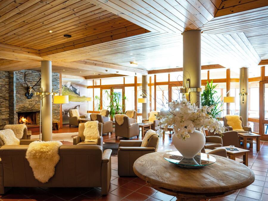 A spacious lobby with multiple seating areas, a fireplace, and large windows.