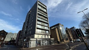 A multi-story building with a modern design, featuring large windows and a prominent entrance. - Clyde Waterfront Apartments (Glasgow)