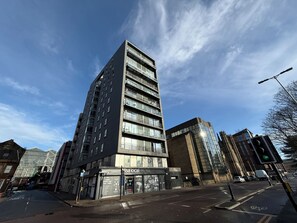 A multi-story building with a modern design, featuring large windows and a prominent entrance. - Clyde Waterfront Apartments (Glasgow)
