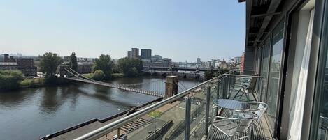 A high-rise building with a view of a river and a bridge.