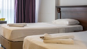 Two single beds with beige linens and pillows, a wooden headboard, and a wooden floor. - Alkan Hotel (Marmaris)