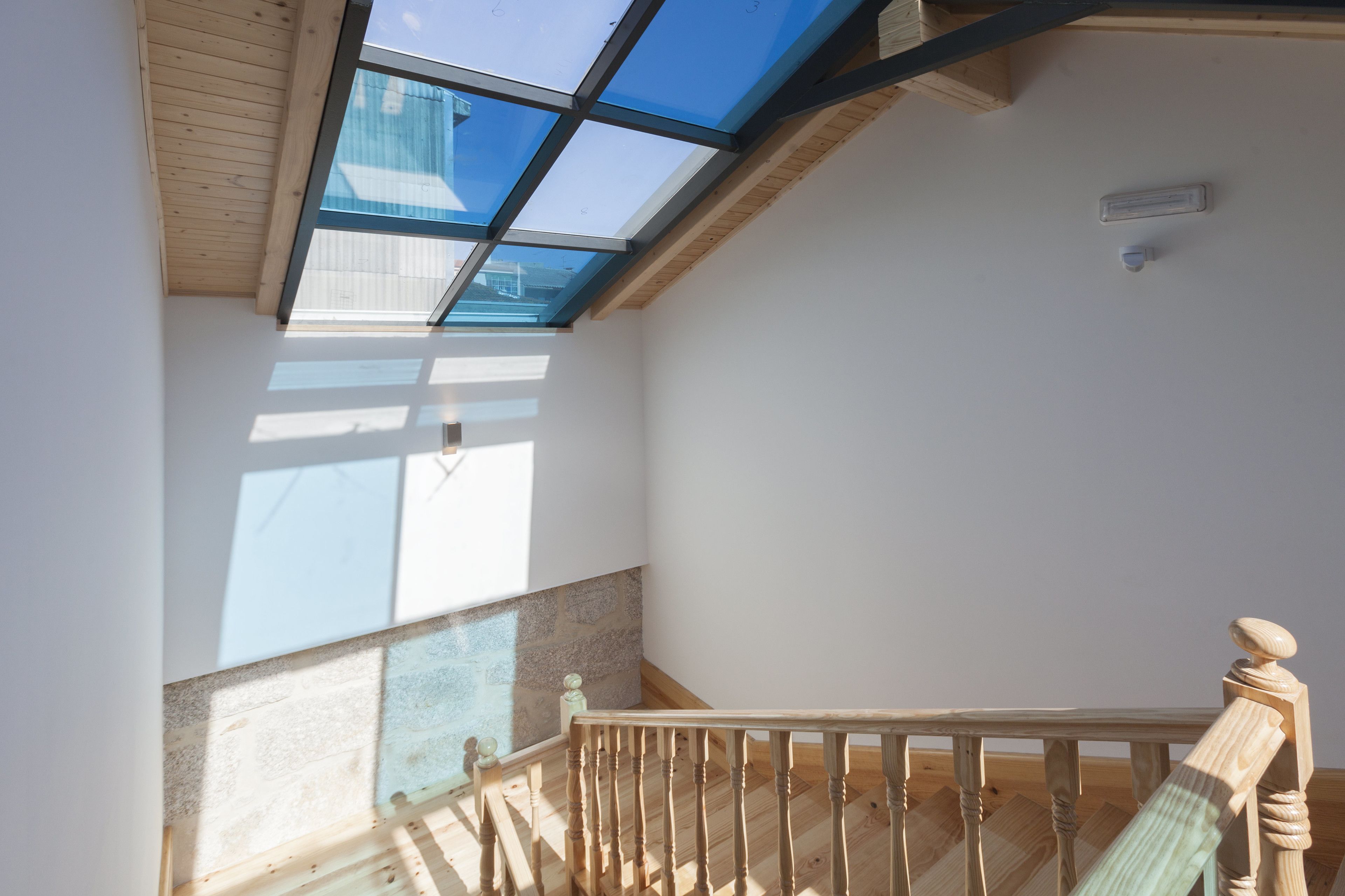 A room with a skylight, wooden ceiling, and a view of the outside.