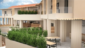 Un immeuble moderne à plusieurs étages, doté d’espaces de détente en plein air et d’un jardin sur le toit.