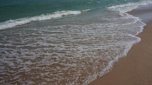 Una playa con olas lamiendo suavemente la orilla.