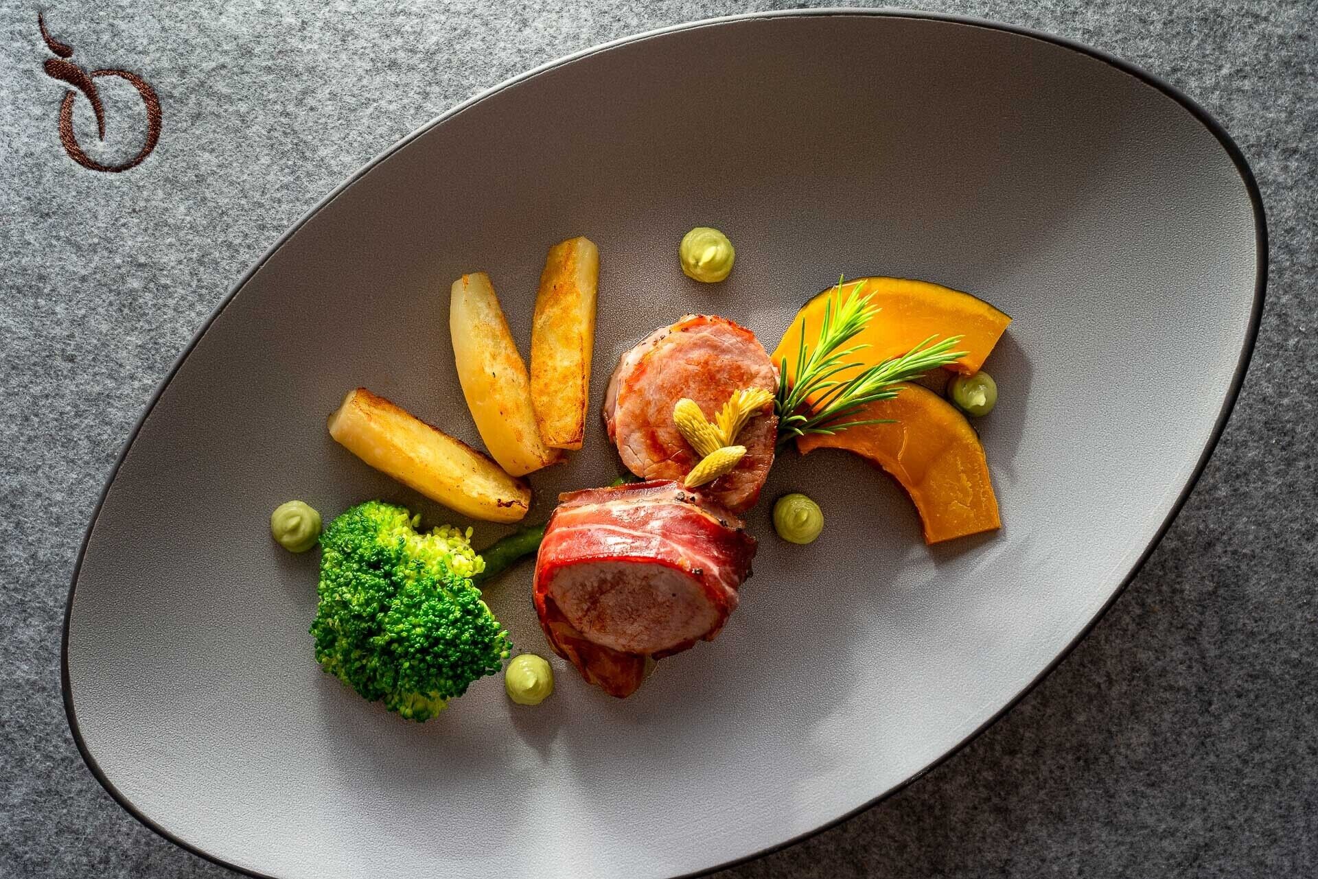 Un plato con carne, papas fritas, brócoli y una guarnición.