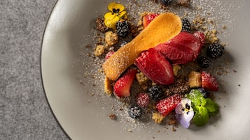 A dessert plate with various fruits and a wooden spoon.