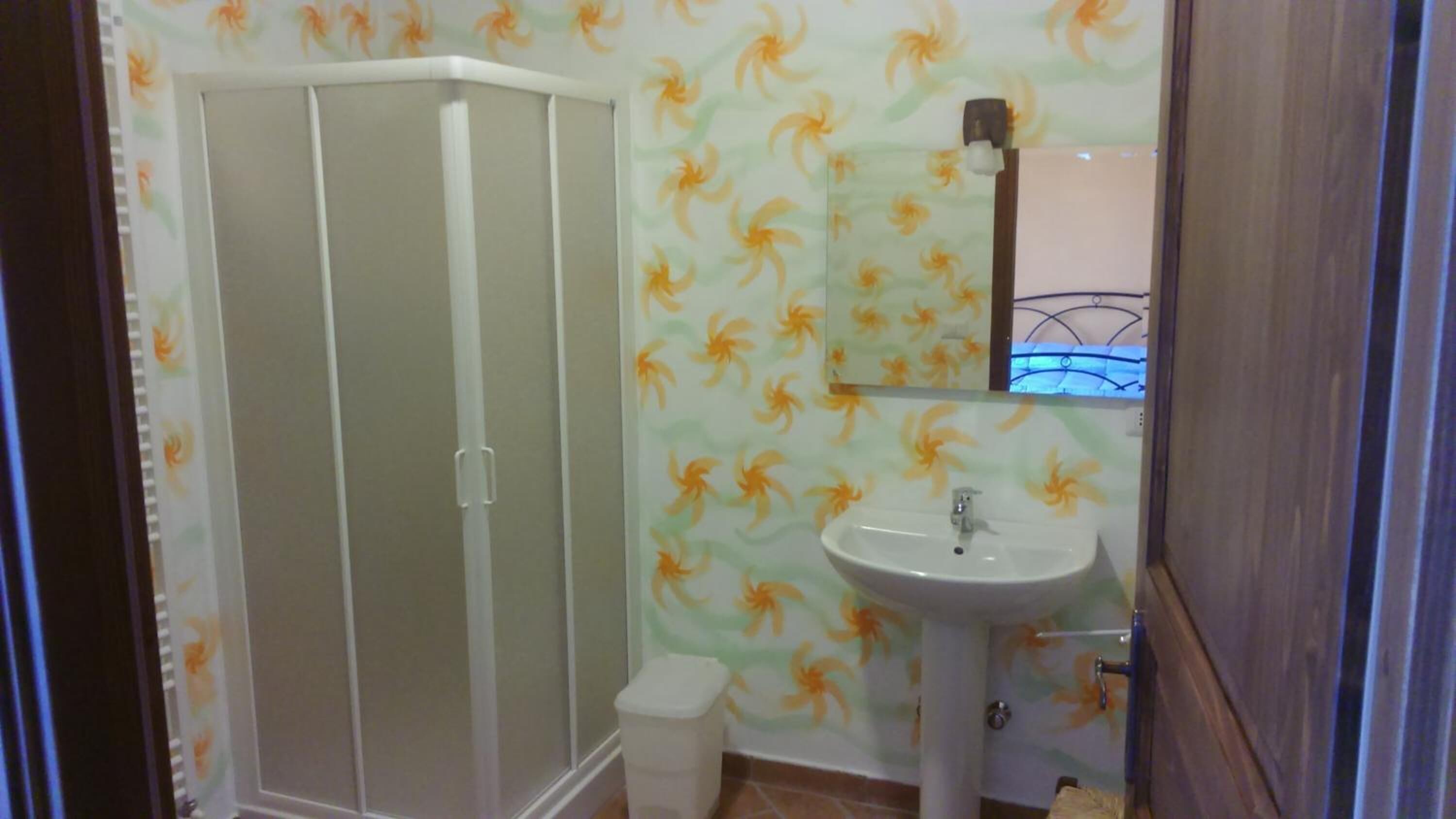 Een badkamer met douche, toilet en wastafel.