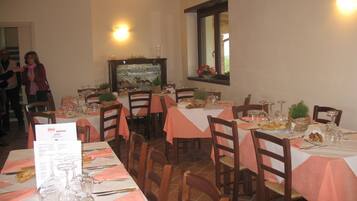 A restaurant with multiple tables set for dining, each with a menu, wine glasses, and cutlery.