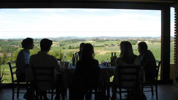 A group of people seated at a table with a view of a rural landscape.
