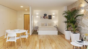 A modern bedroom with a bed, bedside tables, a round dining table, and chairs. - Oporto Local Studios (Porto)